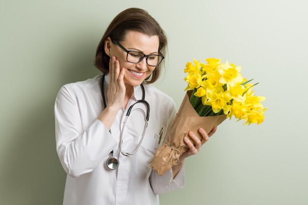 Фото Улыбающиеся женщина-врач с букетом цветов.
