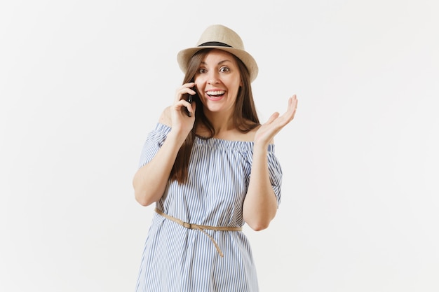 Sorridente donna vestita vestito blu, cappello parlando al telefono cellulare, conducendo una piacevole conversazione isolata su sfondo bianco. persone, emozioni sincere, concetto di stile di vita. zona pubblicità. copia spazio.