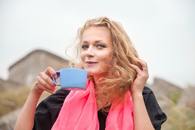 Photo smiling woman drinking coffee outdoors