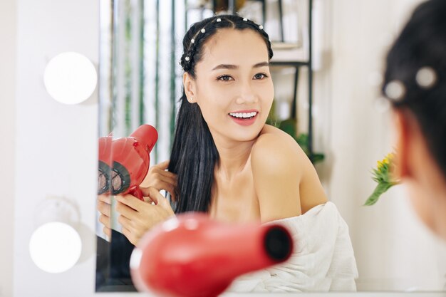 Smiling woman drying her hair