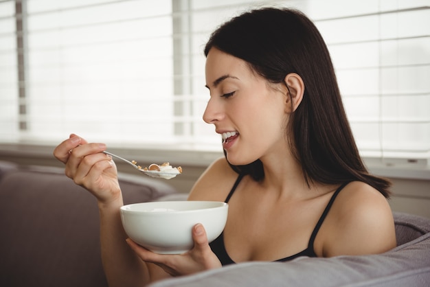 Donna sorridente che mangia prima colazione