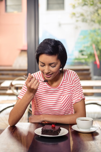 Smiling woman eating a chocolate cake