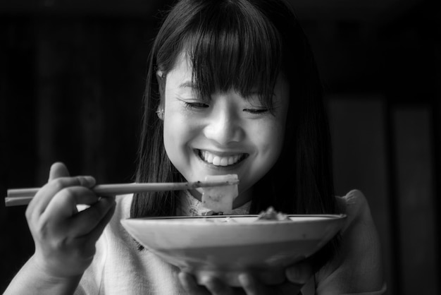 사진 가락 으로 음식 을 먹는 미소 짓는 여자