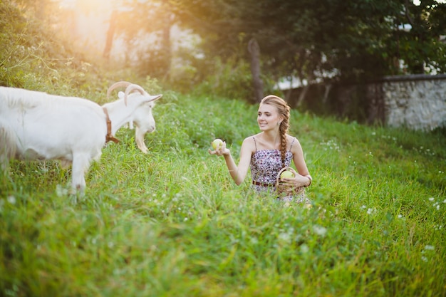 Smiling woman feeding goat