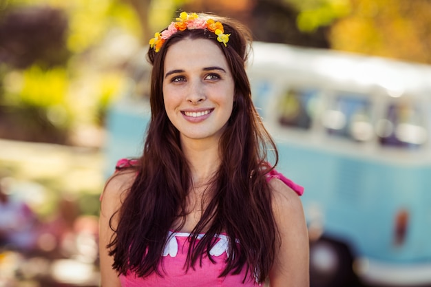 Smiling woman in flower wreath standing in park