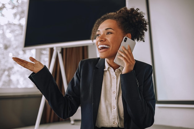 Smiling woman gesturing talking on smartphone