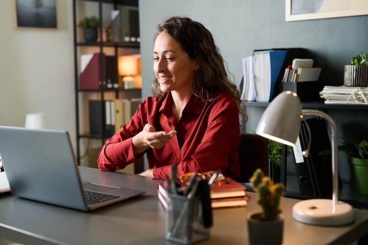 Photo smiling woman gesturing while working in modern office space