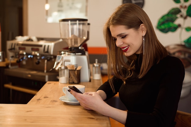 Smiling woman in a good mood enjoy cup of coffee sitting in a cafe. 