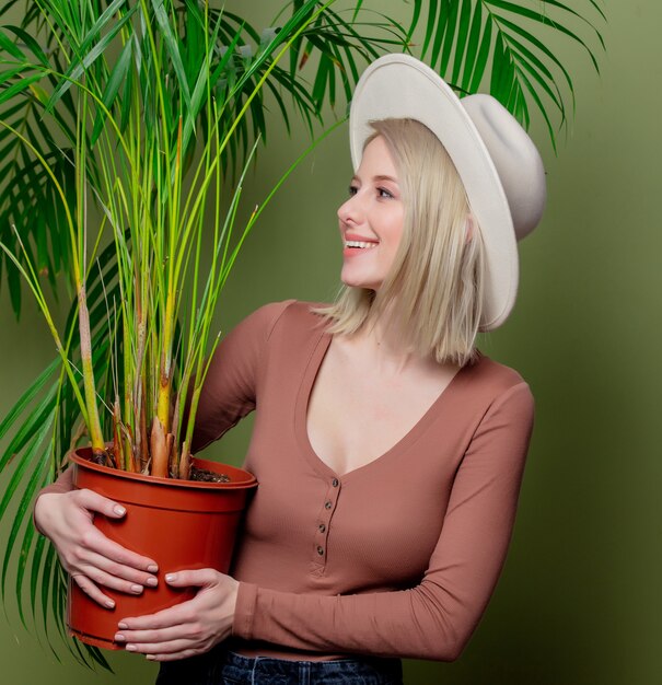 Smiling woman in a hat with palm in a hands