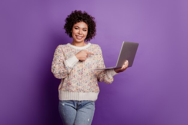 Smiling woman hold laptop computer indicate finger gadget advertisement