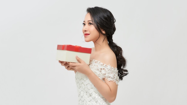 Улыбающаяся женщина держит красную подарочную коробку Концепция Нового года, Рождества и Дня святого Валентина