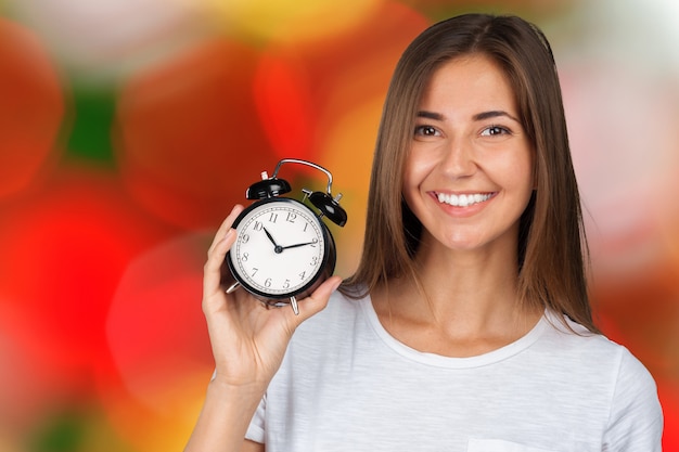 Smiling woman holding alarm watch