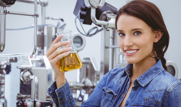 Smiling woman holding a beaker of beer 