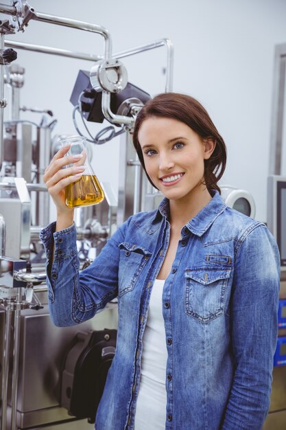 Smiling woman holding a beaker of beer 