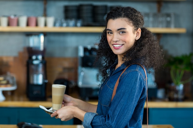 コーヒーショップでコーヒーのカップを保持している女性の笑顔