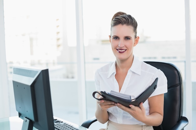 Photo smiling woman holding her datebook