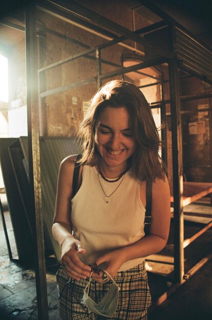 Foto donna sorridente con una maschera in piedi nell'edificio