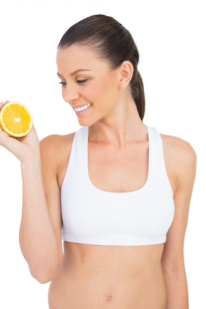 Smiling woman holding orange slice