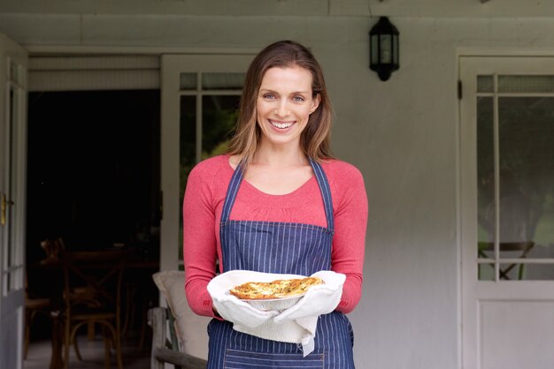 Smiling woman holding pie 