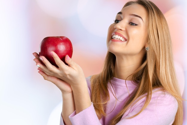 Smiling woman holding red apple