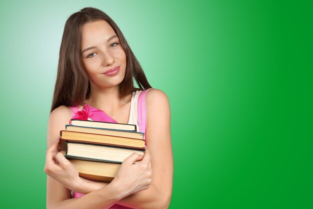 Smiling woman holding stack of books