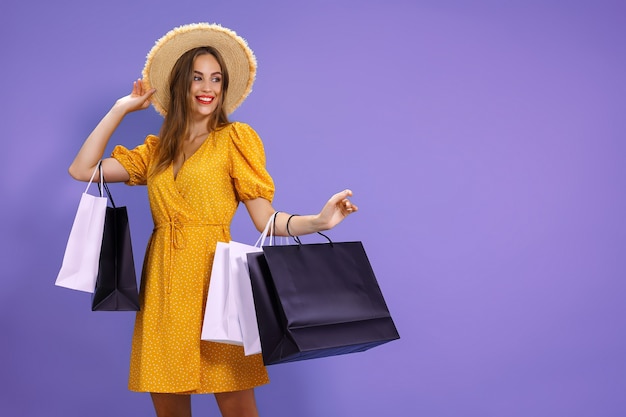 Smiling woman holds shopping bags on colorful background salepurchases shopping black friday