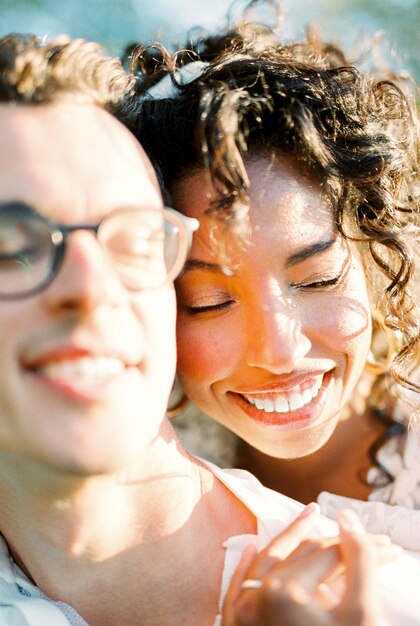 Photo smiling woman hugging a smiling man from behind