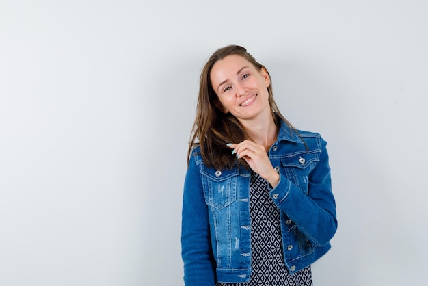 The smiling woman is holding her hair  on white background