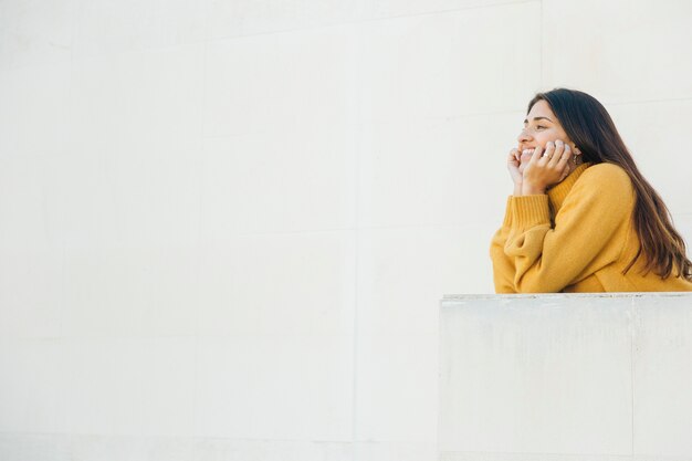 smiling woman leaning on balcony looking away