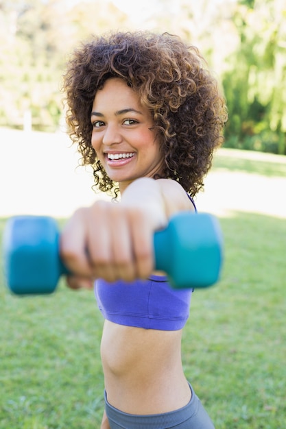 Smiling woman lifting hands weights