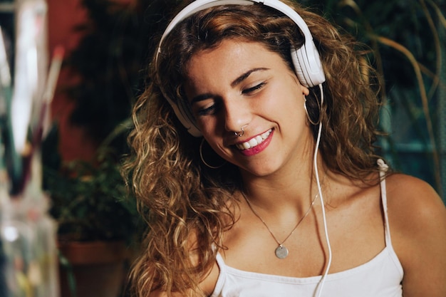 Smiling woman listening music while sitting at home