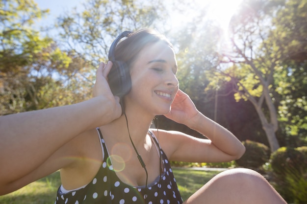 Улыбающаяся женщина слушает музыку в наушниках
