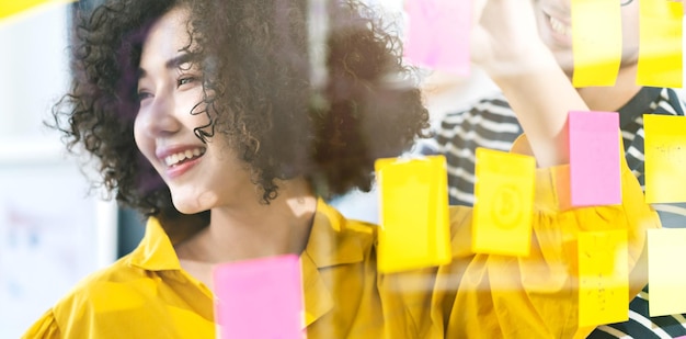 Photo smiling woman looking away standing by adhesive notes