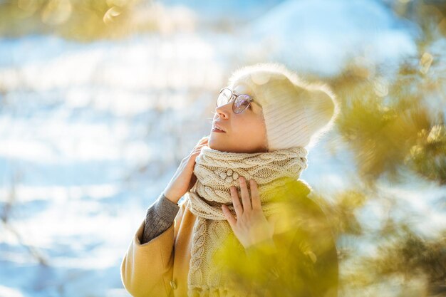 Foto donna sorridente che guarda da un'altra parte mentre è all'aperto durante l'inverno