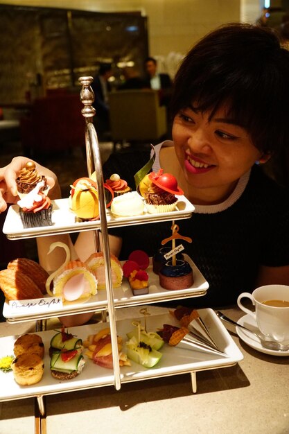 Smiling woman looking at cakes on table