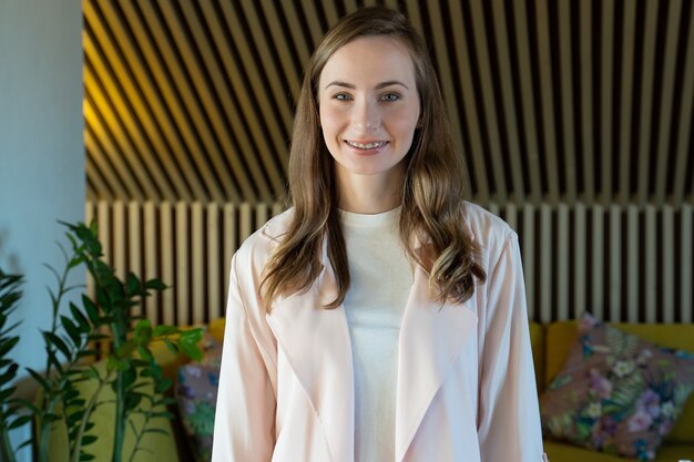 Smiling woman looking at camera posing alone at home