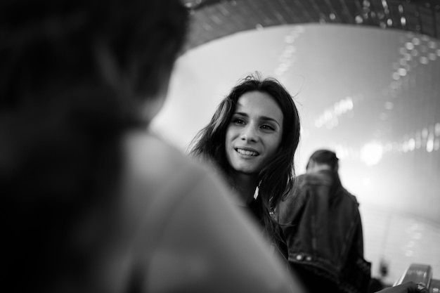 smiling woman looking at friend outdoors
