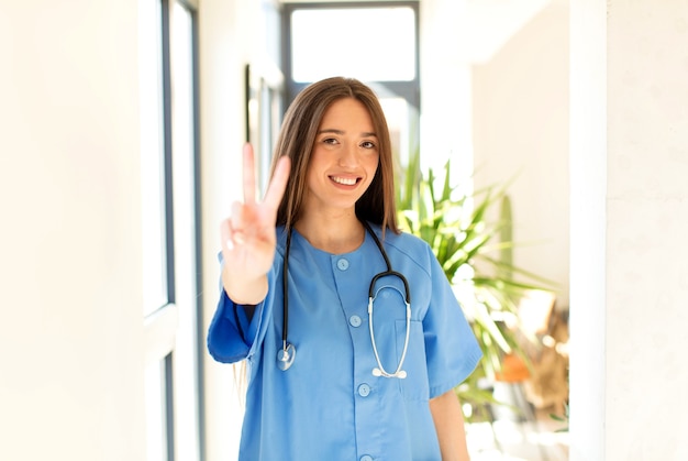 Sorridente e donna che sembra felice, spensierata e positiva, gesticolando vittoria o pace con una mano