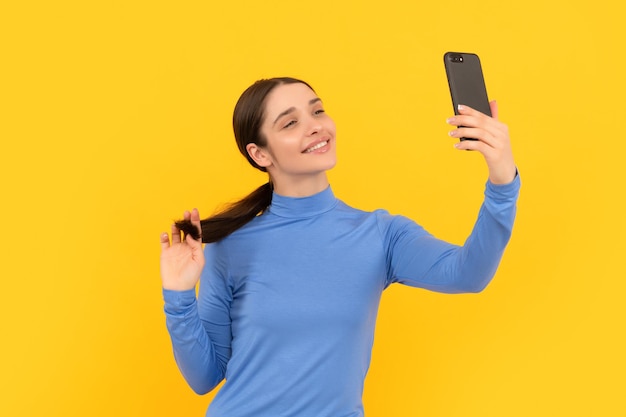 Smiling woman making selfie photo on smartphone selfie