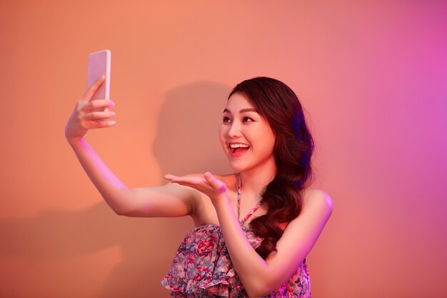 A smiling woman making selfie photo on smartphone