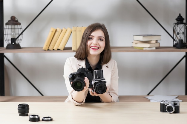 Smiling woman offering camera to you.