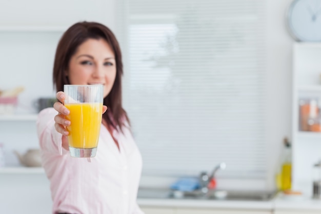 Foto donna sorridente che ti offre succo d'arancia