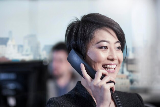 Smiling woman in office talking on phone