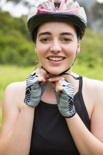 Smiling woman opening her helmet