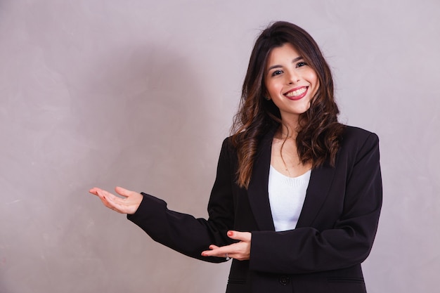 Smiling woman pointing to the side with free space for text.