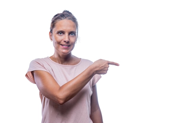 A smiling woman pointing with her finger looking at camera