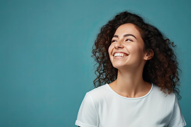 A smiling woman posing and standing over a blue background