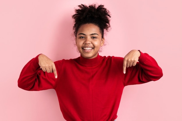 Photo smiling woman posing while pointing down