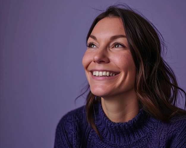 Smiling woman in purple sweater against purple background