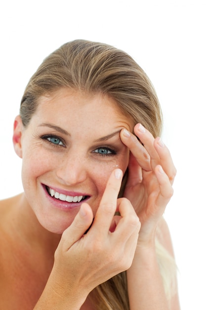 Smiling woman putting a contact lens